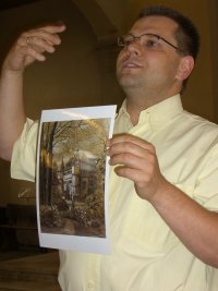 Pastor Gero Albert in Menzingen church holding picture of Wasserschloss