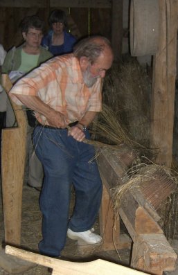 Guide working flax at Hohenlohe Freilandmuseum